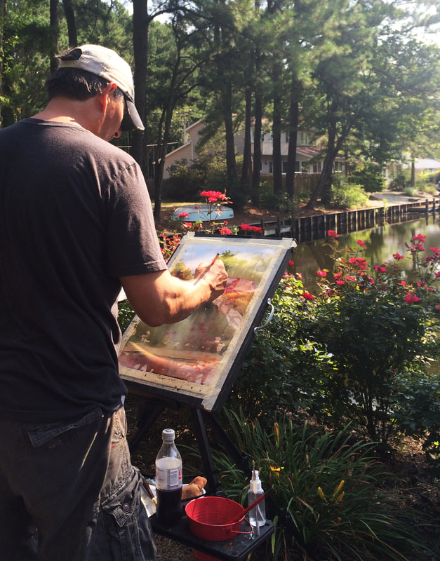 Photograph of artist Leo Kahl painting a watercolor outdoors